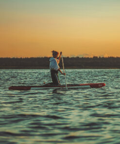 naine sup lauaga merel, päikeseloojang ja mets tagataustal